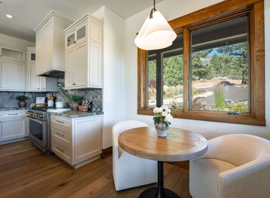 Experience modern living in this stunning kitchen, featuring sleek white cabinetry, marble countertops, and a professional-grade gas range.