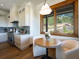 Experience modern living in this stunning kitchen, featuring sleek white cabinetry, marble countertops, and a professional-grade gas range.