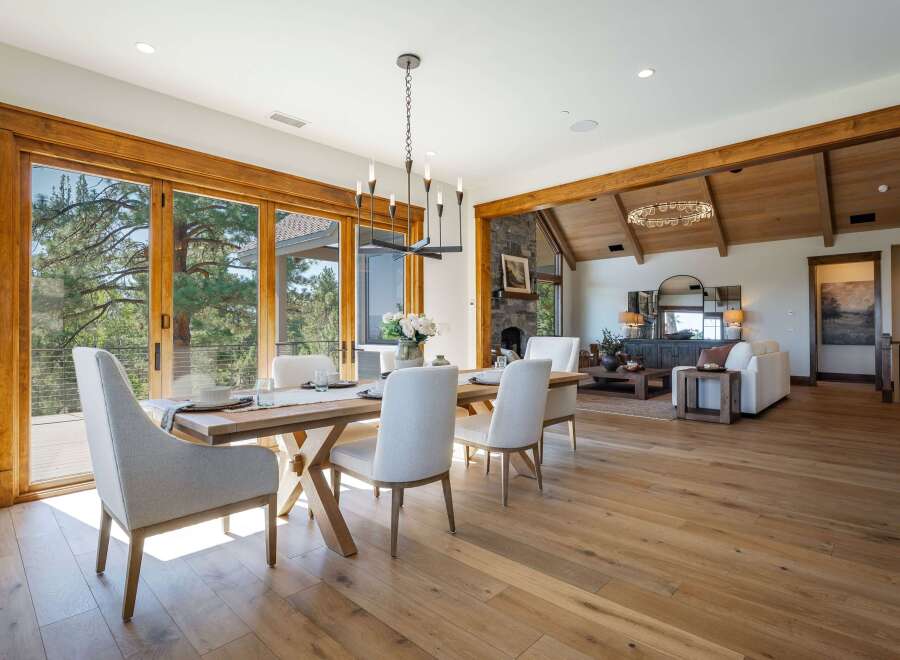 Experience luxurious open-concept living with this stunning dining and living area, featuring expansive sliding glass doors that open to breathtaking natural views.