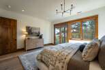 Experience luxury living in this stunning bedroom featuring a large wooden dresser adorned with a beautiful landscape painting and a table lamp.