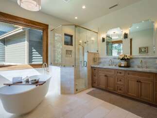 Experience luxury in this stunning bathroom featuring a freestanding soaking tub and a spacious glass-enclosed shower.