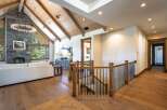 Experience luxury living in this stunning home featuring a grand living area with a soaring stone fireplace and vaulted wood-beamed ceilings.