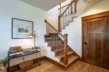 Ascend to the upper level via this beautifully crafted wooden staircase, featuring a sleek black metal railing and sturdy oak treads.