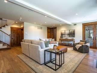 Experience luxurious living in this spacious great room, featuring a comfortable sectional sofa, a stylish accent chair, and a large area rug.