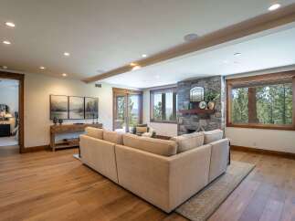 Experience luxurious living in this stunning home featuring a spacious living area with a stone fireplace and large windows offering breathtaking mountain views.