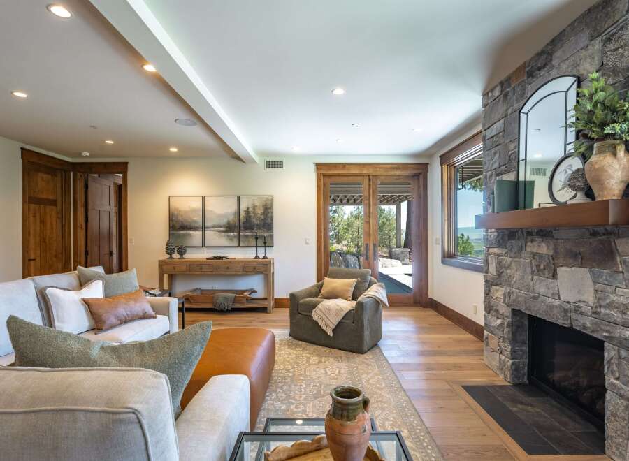Experience luxurious living in this stunning great room, featuring a magnificent stone fireplace and expansive windows that offer breathtaking views.