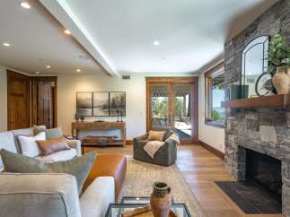 Experience luxurious living in this stunning great room, featuring a magnificent stone fireplace and expansive windows that offer breathtaking views.