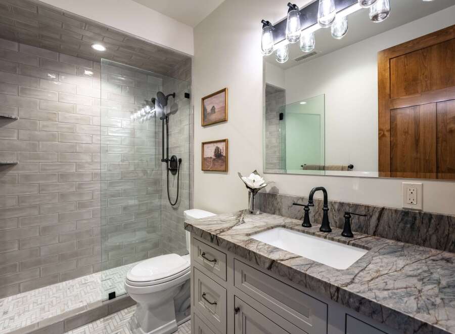 This modern bathroom features a spacious walk-in shower with subway tile and a sleek glass enclosure.