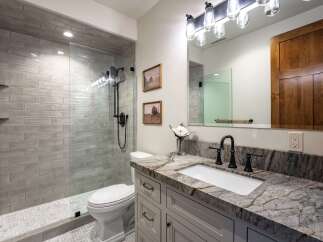 This modern bathroom features a spacious walk-in shower with subway tile and a sleek glass enclosure.
