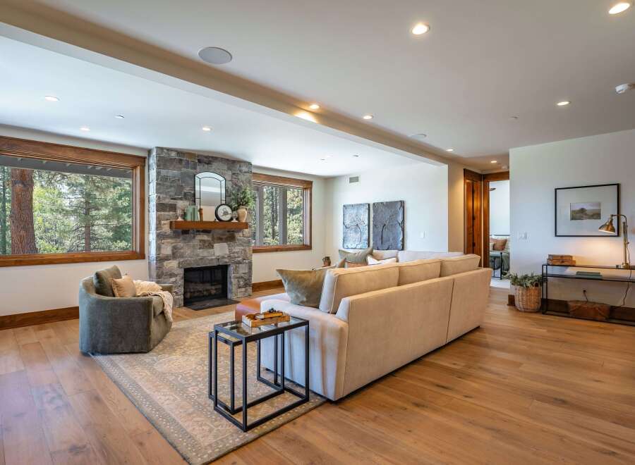 Experience luxurious living in this stunning mountain retreat, featuring a grand stone fireplace as the centerpiece of the spacious living area.