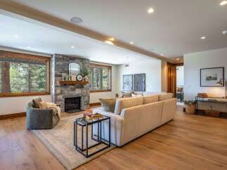 Experience luxurious living in this stunning mountain retreat, featuring a grand stone fireplace as the centerpiece of the spacious living area.