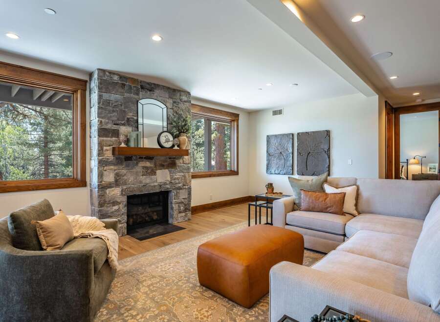 Experience cozy living in this inviting living room, featuring a striking stone fireplace as the focal point.