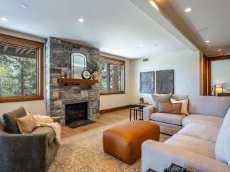 Experience cozy living in this inviting living room, featuring a striking stone fireplace as the focal point.