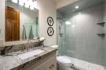 This modern bathroom features a stunning marble vanity with a sleek undermount sink and brushed nickel fixtures.