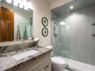 This modern bathroom features a stunning marble vanity with a sleek undermount sink and brushed nickel fixtures.