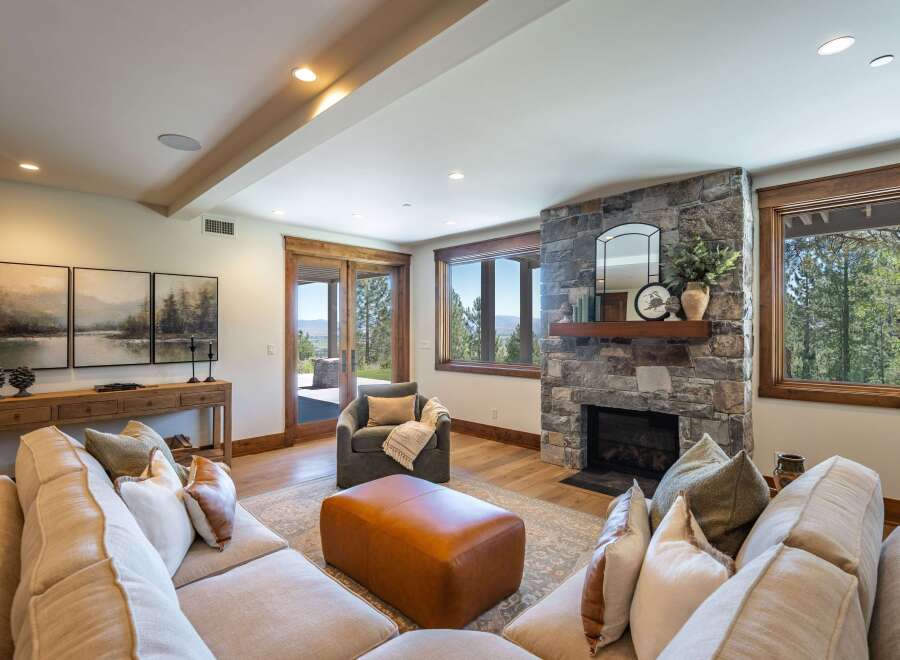 Experience luxury living in this stunning mountain retreat, featuring a grand stone fireplace and expansive windows that frame breathtaking natural views.