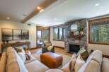 Experience luxury living in this stunning mountain retreat, featuring a grand stone fireplace and expansive windows that frame breathtaking natural views.
