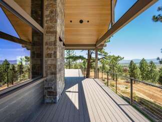 Experience breathtaking panoramic views from this stunning modern home's expansive deck, perfect for entertaining or quiet relaxation.