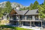 Experience luxury mountain living in this stunning home, featuring expansive decks with breathtaking views and a grand stone fireplace.