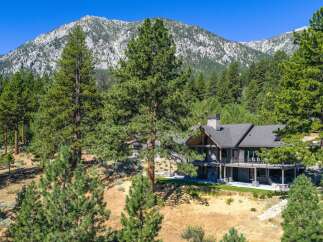 Nestled amidst towering pine trees and against a majestic mountain backdrop, this stunning home offers unparalleled natural beauty and luxurious living.