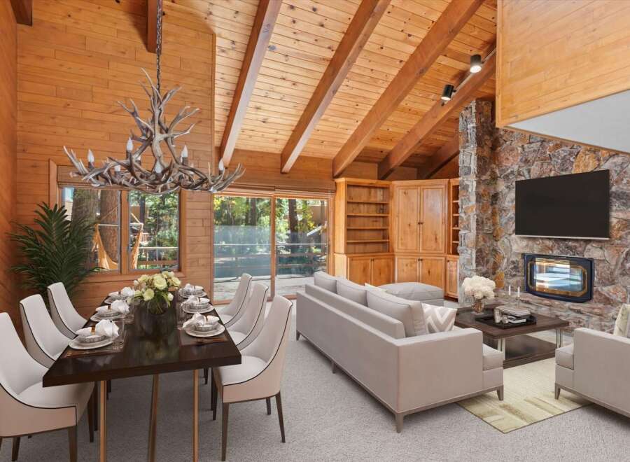 Experience rustic charm in this stunning living and dining area, featuring a grand antler chandelier and a magnificent stone fireplace.