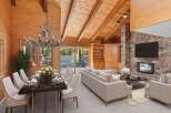 Experience rustic charm in this stunning living and dining area, featuring a grand antler chandelier and a magnificent stone fireplace.
