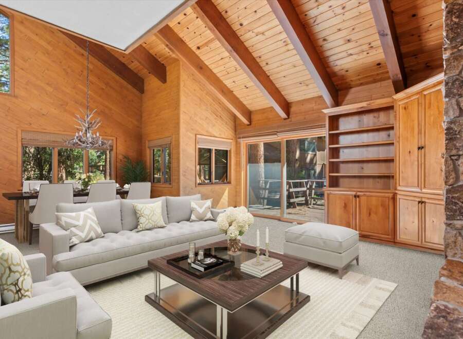 Experience rustic elegance in this stunning living room, featuring a vaulted wood-paneled ceiling with exposed beams and a cozy stone fireplace.