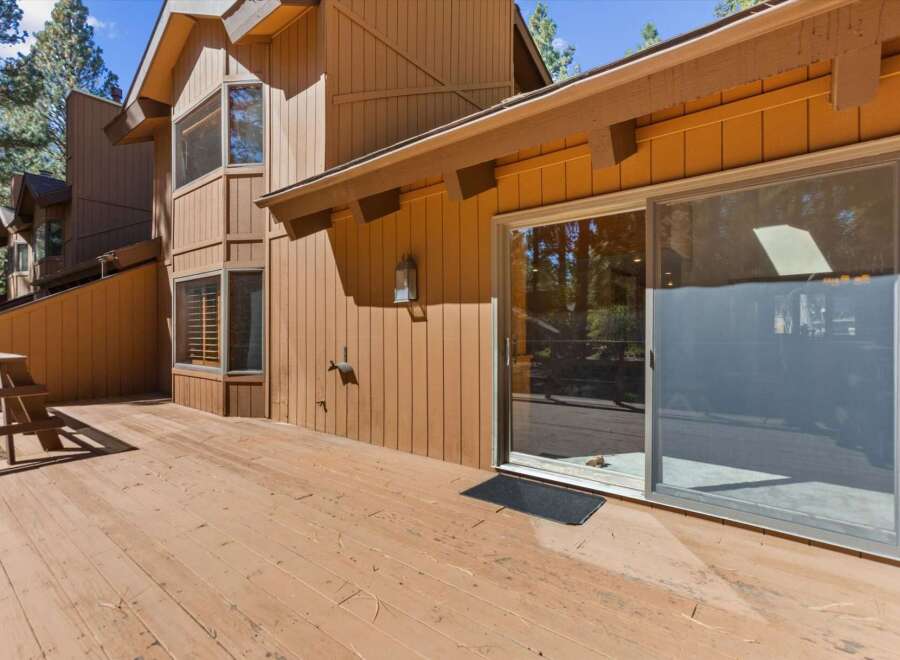 Enjoy the outdoors on this expansive wooden deck, perfect for entertaining or relaxing amidst the trees.