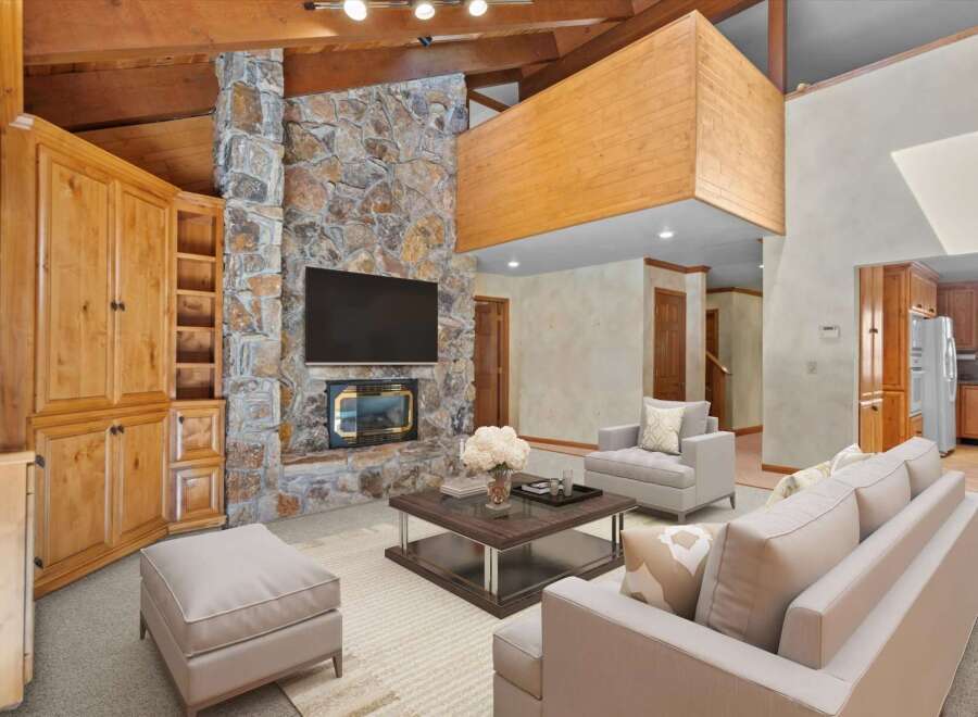 Experience rustic charm in this spacious living room, featuring a grand stone fireplace as the centerpiece.