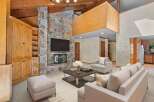 Experience rustic charm in this spacious living room, featuring a grand stone fireplace as the centerpiece.