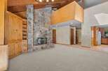 Experience rustic charm in this spacious living area featuring a grand stone fireplace as the centerpiece.
