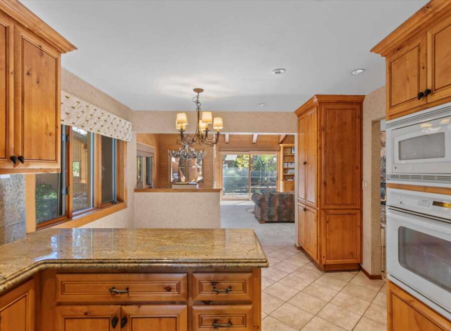 This spacious kitchen features beautiful natural wood cabinetry and a granite countertop, perfect for meal preparation and entertaining.