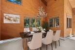 Experience rustic charm in this inviting dining room, featuring warm wood paneling and a unique antler chandelier.