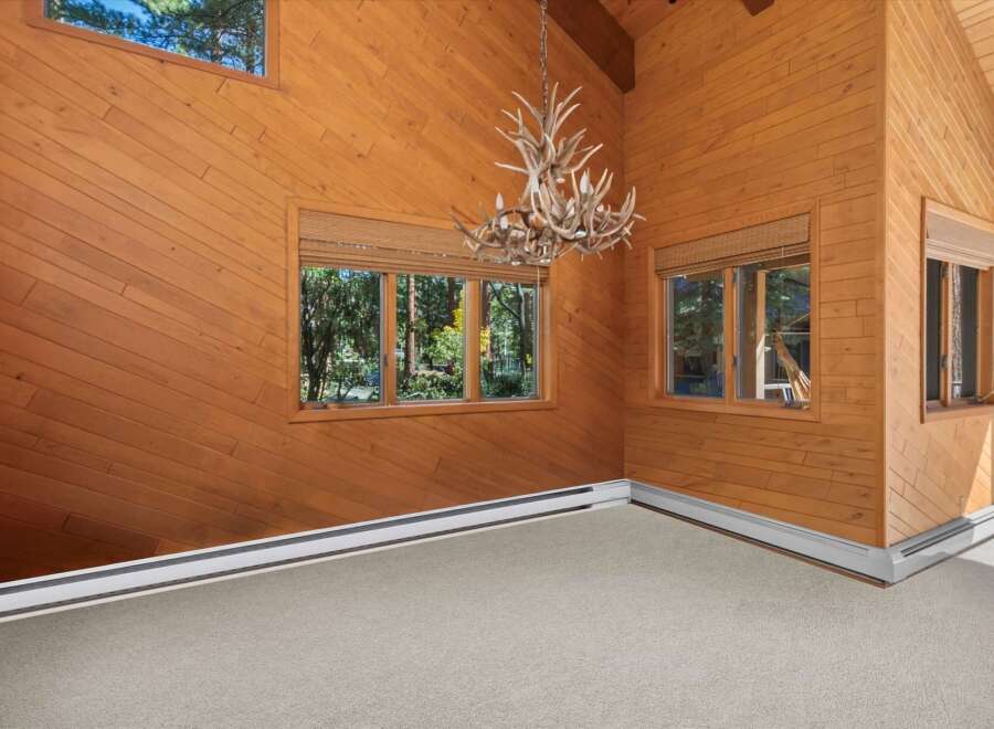 Experience rustic charm in this wood-paneled living space, featuring a unique antler chandelier that adds a touch of wilderness elegance.