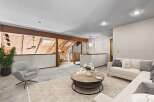 Experience the unique charm of this loft-style living space, featuring exposed wooden beams and a vaulted ceiling with skylights that flood the area with natural light.