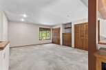 This spacious room features plush carpeting and ample natural light from a large window overlooking lush greenery.