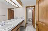This bathroom features a spacious vanity with a white tiled countertop and a large mirror, perfect for your morning routine.