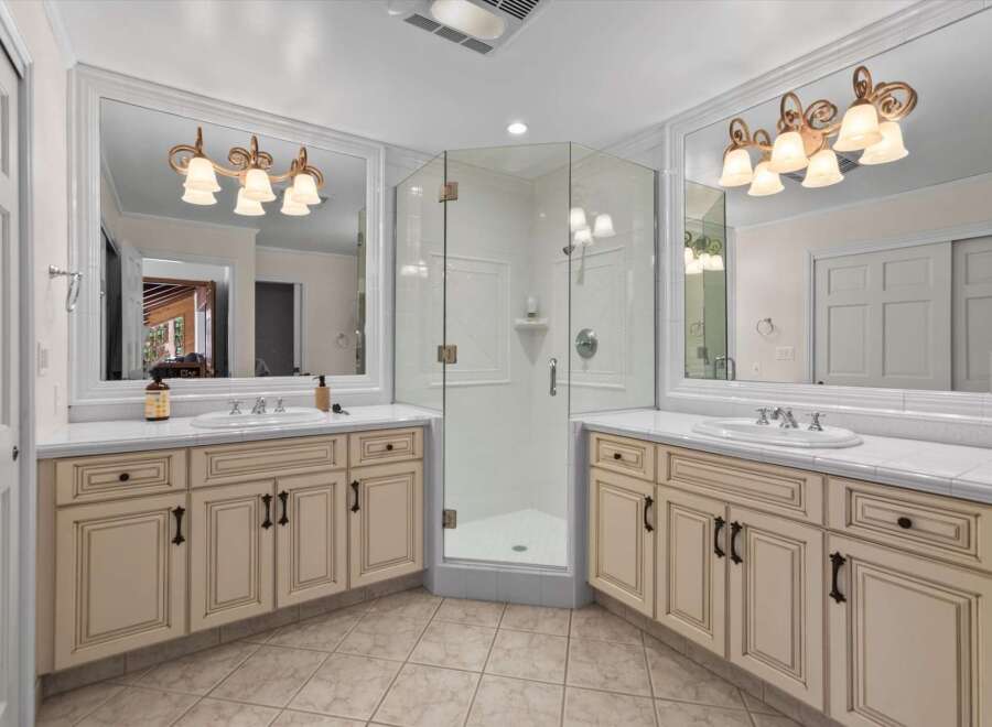 This luxurious bathroom features a spacious corner glass shower, perfect for a spa-like experience.