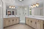 This luxurious bathroom features a spacious corner glass shower, perfect for a spa-like experience.