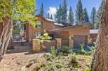 Nestled amongst tall pine trees, this charming property offers a serene mountain retreat.