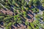 Discover this stunning aerial view of a residential complex nestled amongst lush green trees.