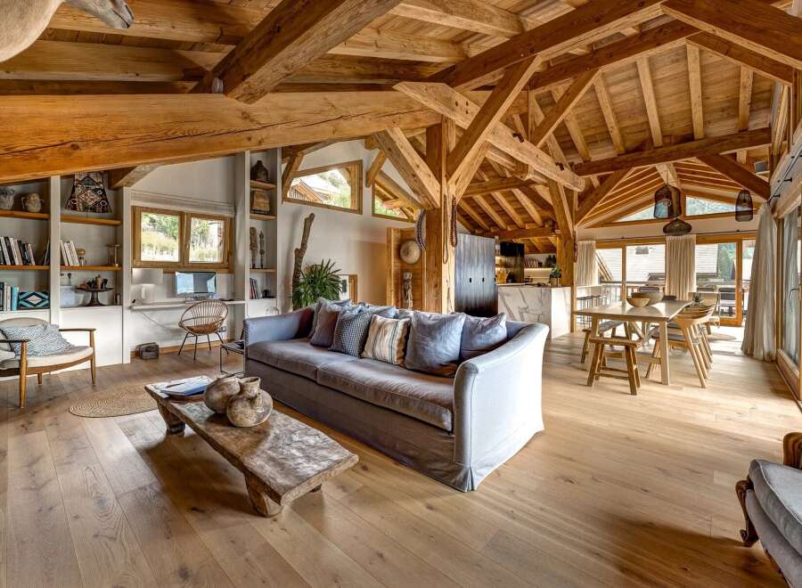 Experience rustic luxury in this stunning living space, featuring exposed wooden beams and a cozy, inviting atmosphere.