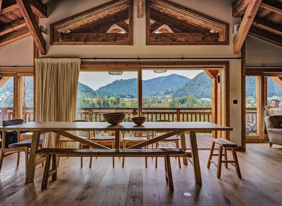 Experience breathtaking mountain views from this stunning chalet dining area.