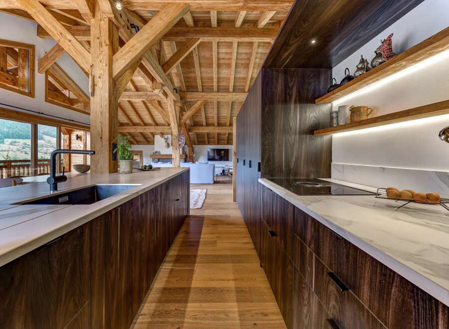 Experience luxury mountain living in this stunning kitchen, featuring rich dark wood cabinetry and elegant marble countertops.