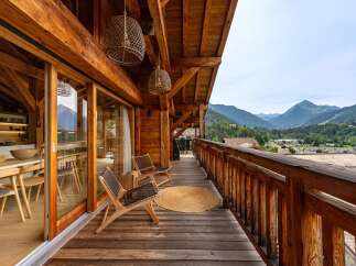 Experience breathtaking mountain views from this stunning wooden balcony, perfect for enjoying your morning coffee or evening relaxation.