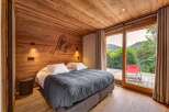Experience rustic charm and modern comfort in this beautifully appointed bedroom, featuring warm wood paneling and a cozy king-sized bed.