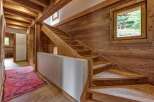 Experience rustic charm in this mountain chalet featuring a stunning wooden staircase and exposed beams.