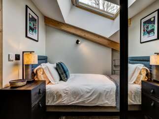 Experience cozy comfort in this charming bedroom, featuring a plush bed adorned with crisp white linens and a decorative blue throw pillow.