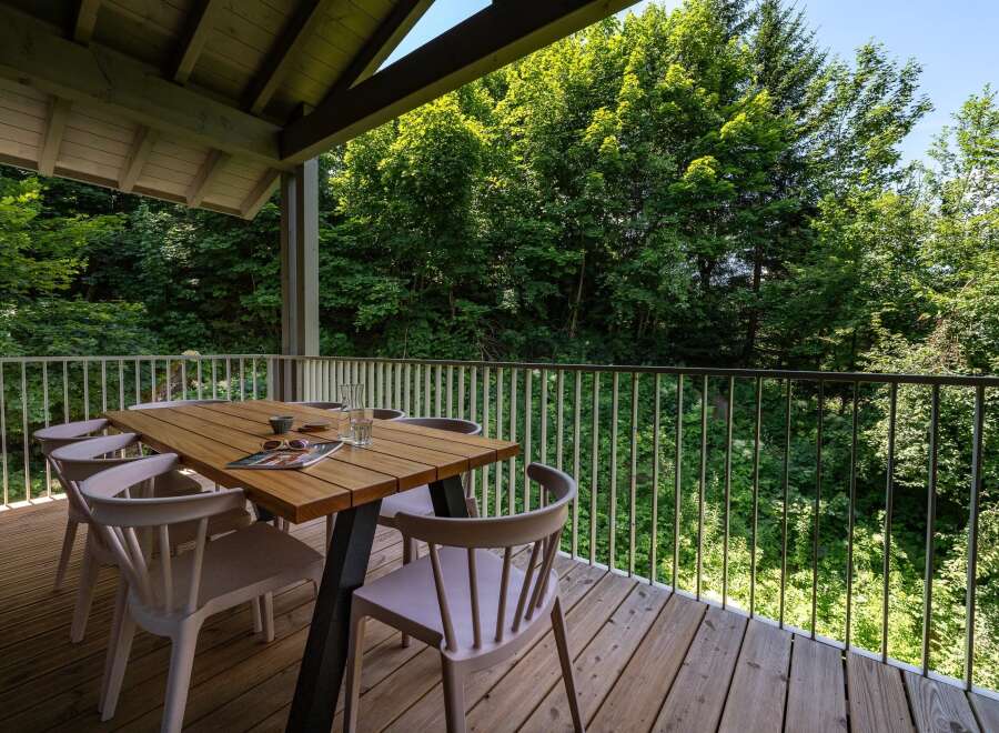 Enjoy al fresco dining on this spacious wooden deck, complete with a modern table and chairs.