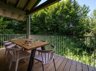 Enjoy al fresco dining on this spacious wooden deck, complete with a modern table and chairs.